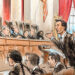 Man speaking with hands raised in front of nine justices on the bench