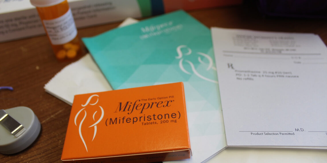 A table with medical pamphlets and a box of the abortion pill mifepristone
