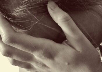 sad woman holds her head in her hands