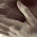 sad woman holds her head in her hands