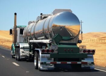 back end of silver big rig driving on a road