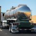 back end of silver big rig driving on a road