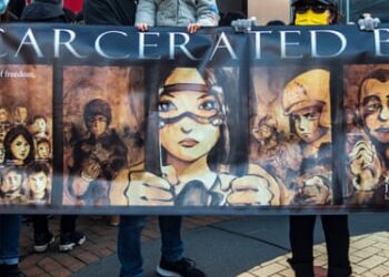 People hold a banner in a human chain in Kingston, London, to protest against political oppression in Hong Kong, January 2022.