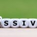 Hand turns a dice and changes the word “passive” to “aggressive”, or vice versa.