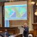 Man points at two different voting maps