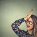 silly woman slapping hand on head having duh moment