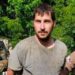 Michael Burham in dirty clothes led out of the woods by FBI