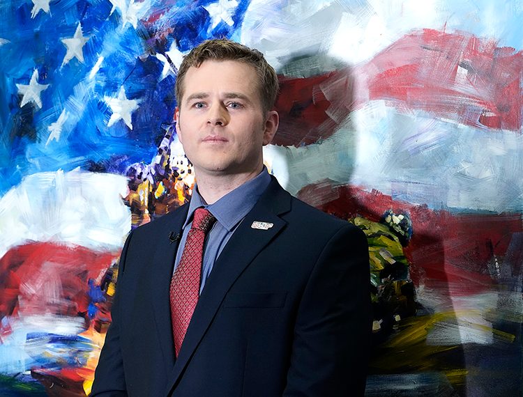 Clint Lorance in front of a painting of an American flag