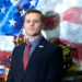Clint Lorance in front of a painting of an American flag