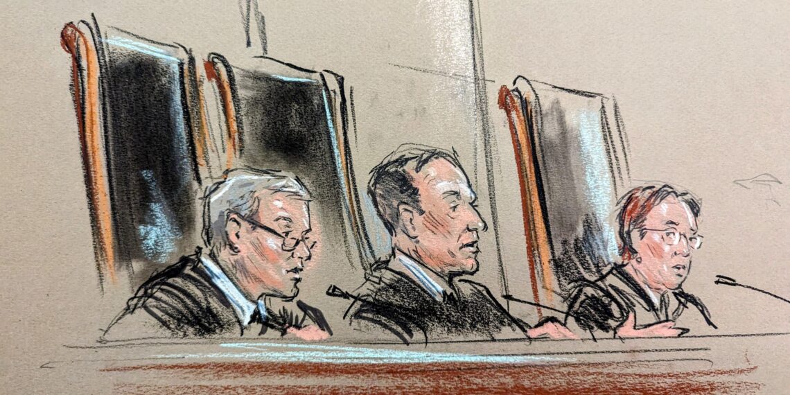 Three justices sitting on the bench with one speaking into a mic