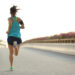 young woman runner running on city bridge road