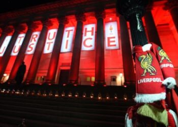 Liverpool scarves hang on a lamp-post as St George’s Hall is lit up in red in 2016.