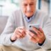 texting Shot of a senior man using a phone at a clinic
