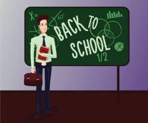 Back to School. Male teacher in a classroom standing near chalk board.