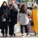 Veiled Iranian women pass by a bareheaded woman in Tehran on a street in Tehran