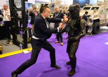 A man wearing a Chiron-X1 high-impact close-quarter fighting training suit is attacked by a member of the sales team during a demonstration at DSEI