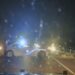 Arkansas Police Officer standing next to car looking out at white car that drove off side of highway