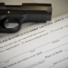 Handgun on top of a black concealed-carry-permit application form