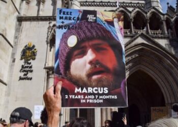 A protester holds a picture of Marcus Decker during a demonstration in July.