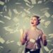 money happy young woman exults pumping fists ecstatic celebrates success under a money rain falling down dollar bills banknotes