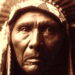 A Native American elder wearing a traditional headdress made of beads and feathers.