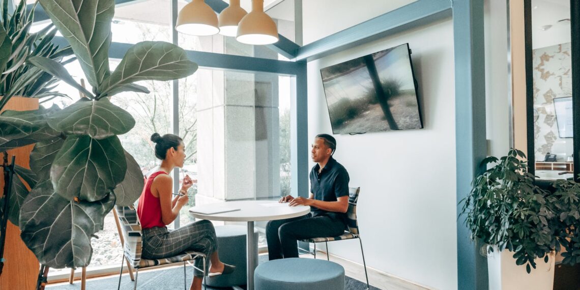 a man and woman sitting on the chair while looking at each other