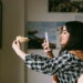 A girl taking a picture of a folded piece of pizza with her phone