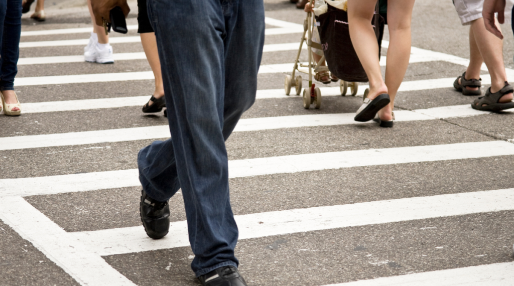 A large group of pedestrians in a large crosswalk.