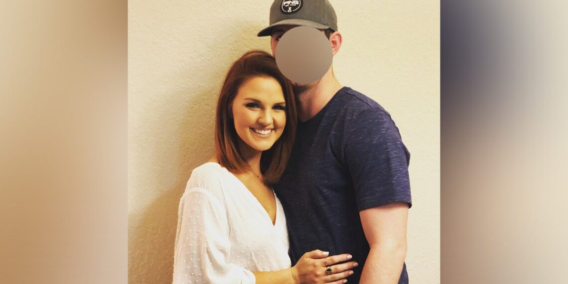 Woman and man wth baseball hat embrace in photo.