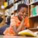 Cute boy reading book in library
