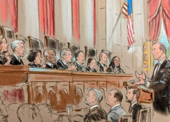 Man speaking before full bench of justices