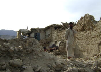 Image 1. Afghan Man standing in the rumble caused by an earthquake. Source: Flickr