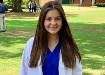 Laken Riley in a medical coat in a grassy field