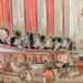 All nine justices speaking on the bench to lawyer at lectern with group looking on.