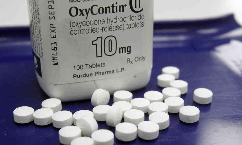 Alternate Text: Image of white OxyContin bottle with white pills laid out in front. Source: Flickr