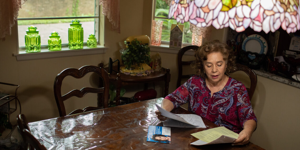 Woman sitting at a table reading documents