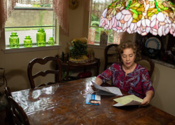 Woman sitting at a table reading documents