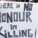 An image with a group of people holding up a banner that reads, "There is no honor in killing!"