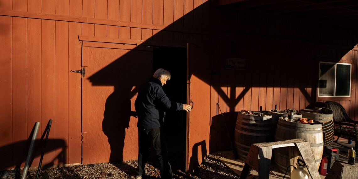 A man holds open a barn door