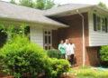Three people standing outside the door of a group home