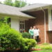 Three people standing outside the door of a group home